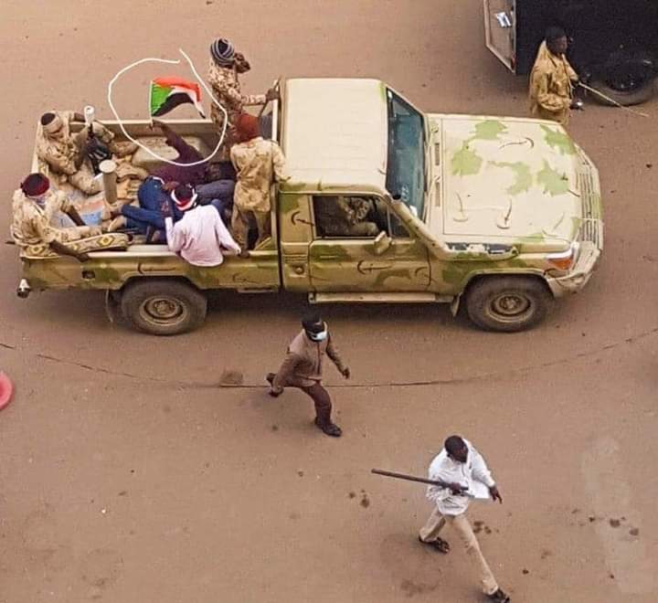 حظيت باهتمام كبير … صورة لثائر مقبوض عليه يلوح بعلم السودان من داخل عربة أمن